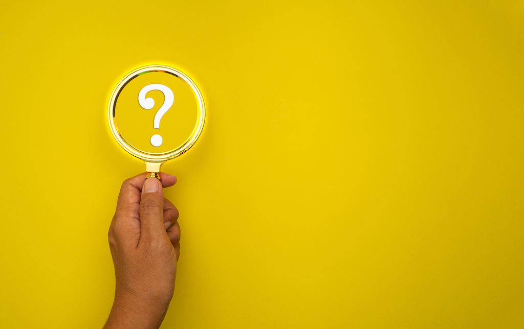 Yellow background with magnifying glass on white question mark.